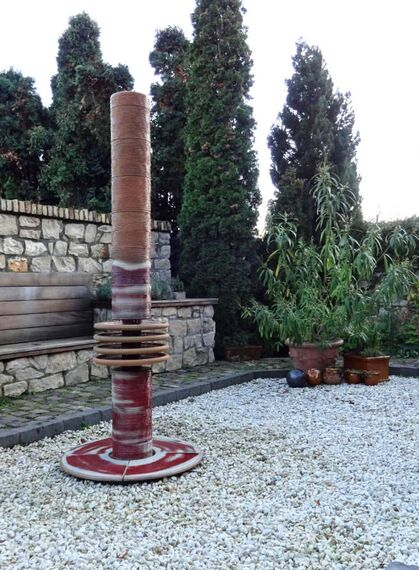 Moderner Gartenbrunnen aus winterfester Keramik mit gerillter Säule und kaskadenförmigen Tellern rot-weiß, dezente Akustik