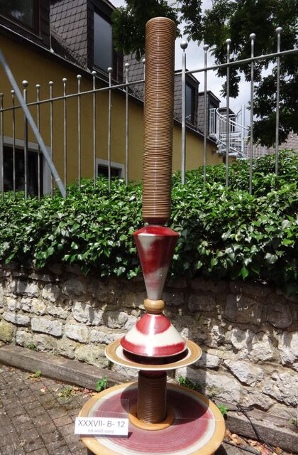 Designerbrunnen vom Künstler mit gerillter Säule und Lichtreflexen über zwei farbige Kegel, dezente Akustik