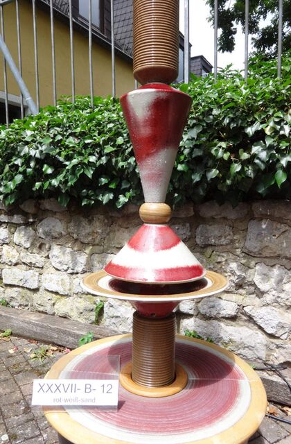 Designerbrunnen vom Künstler mit gerillter Säule und Lichtreflexen über zwei farbige Kegel, dezente Akustik