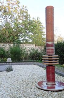 Moderner Gartenbrunnen aus winterfester Keramik mit gerillter Säule und kaskadenförmigen Tellern rot-weiß, dezente Akustik